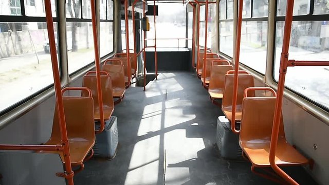 Empty orange chairs in an empty public tram during coronavirus pandemic