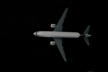 Obraz premium model of a plane isolated on black background flat lay