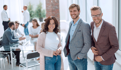 three young employees standing in a modern office.