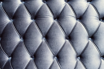 Front of blue upholstered furniture. Rhomboidal shape. Horizontal.