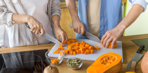 Young unrecognizable couple preparing healthy lunch of fresh baked pumpkin