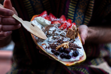Man eating healthy breakfast in papaya bowl