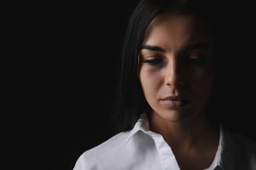 Scared female victim on dark background. Concept of violence