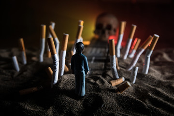 Ashtray and butts cigarettes on dark background. Selective focus