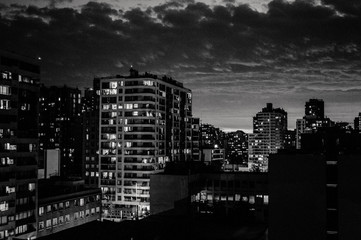 Ciudad de noche en blanco y negro, atardecer con nubes