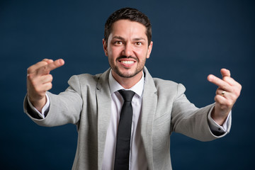 Portrait of business young handsome male showing double obscene gesture