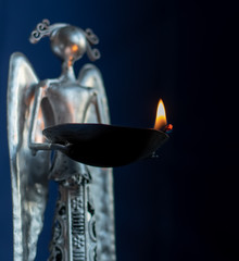 Metallic angel holding a flame of hope