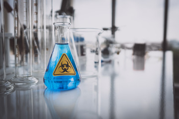 Yellow Biohazzard sign on Chemical Glassware in Lab