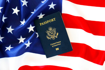 Latest version of United States of America citizen Passport with biometric ID chip on USA national flag. Person identification document. Close up, copy space, background, top view, flat lay.