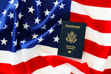 Latest version of United States of America citizen Passport with biometric ID chip on USA national flag. Person identification document. Close up, copy space, background, top view, flat lay.