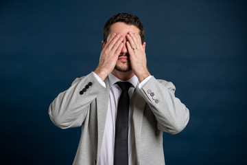 Portrait of business young male covering eyes like blind gesture