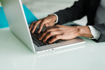 Close up of african hands working on laptop