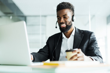 Operator of hot line. Portrait of cheerful african customer service representative with headset in...