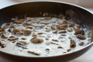 mushrooms in a creamy sauce in a pan. Homemade cooking.