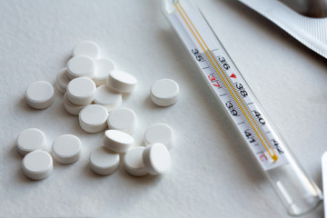 medical thermometer and pills. white tablets against coronavirus. Covid-2019. Covid-2020.