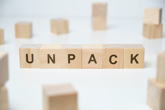 Modern business buzzword - unpack. Word on wooden blocks on a white background.