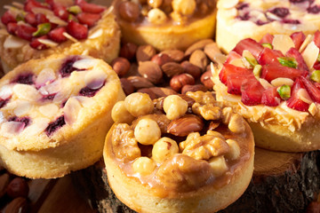 Mini tarts cupcakes with strawberries, walnuts, almond, nuts and blueberries. Close up