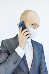 image of business man wearing anti bacterial mask against virus and pollution with smartphone in hand