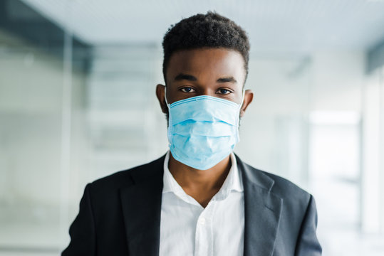 Young African Man In Medical Mask On His Face In Office