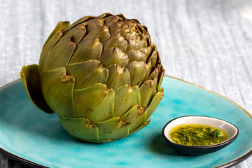 Obraz premium cooked artichoke on a blue plate