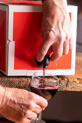 pouring red wine from a box