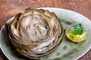 cooked artichoke on a green plate