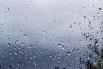 Drops of rain on the window with sky background