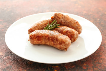 Plate with tasty grilled sausages on color background