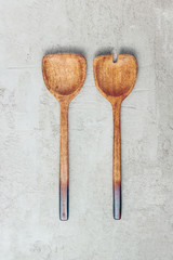 Wooden salad serving utensils set. Spoon and fork on concrete background. Minimal kitchenware concept. Top view. Flat lay. Copy space.