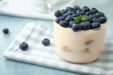 Tasty tiramisu with berries on color background