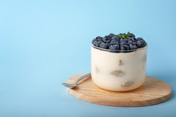 Fototapeta na wymiar Tasty tiramisu with berries on color background