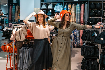 Trade, buyers. Two beautiful girls make purchases in a shopping center, go shopping. The joy of consumption.