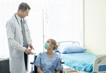 Fototapeta premium Senior doctor consults or discussing medicine to young patient woman put on a protective medical mask while sitting at the clinic or hospital. Medicine and Healthcare concept. Doctor and patient