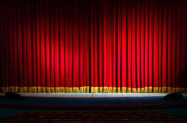 Red curtains in a theater scene of the show. Closed theater curtain of red velvet, texture,...