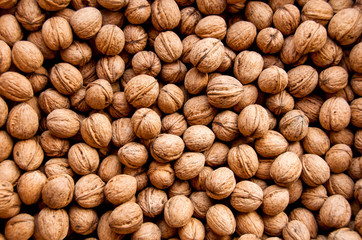 Background from walnuts. Nuts background closeup. Natural organic food.  Assortment of walnuts.  Whole walnuts and nutcracker background. Top view. Harvest concept.