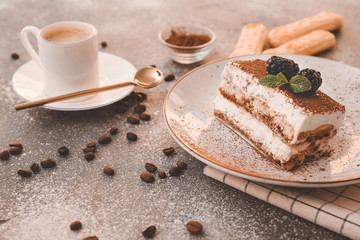 Plate with tasty tiramisu and cup of coffee on grey background