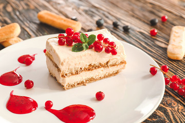 Plate with tasty tiramisu on table