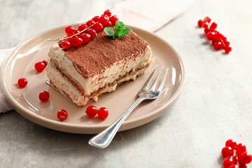 Plate with tasty tiramisu on table