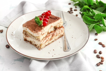 Plate with tasty tiramisu on table
