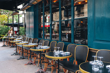 Tables and chairs in outdoor cafe in Paris, France. - obrazy, fototapety, plakaty