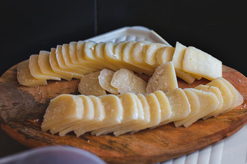 slices of cured cheese on a cutting board, delicious food