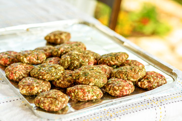 Raw homemade kebab or meatball with green parsley, garlic, spices and sliced onion. It is a very popular in Middle East. BBQ outdoor party.