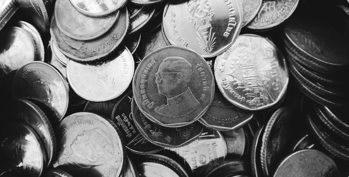 Thai currency. A pile of coins. Thai King. Five baht coins. Coin background. Money background. Black and white.