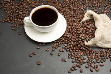 White coffee cup And a bag of roasted coffee beans placed on the black table Is a well-selected...