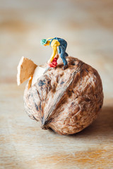 un personnage miniature découpe à la tronçonneuse une noix