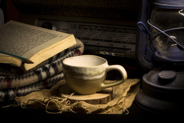 a cup of coffee with book and lantern