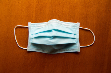 Close up medical face mask on wooden table background, Selective focus to green face mask on wood...
