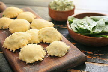 Raw ravioli with spinach on table