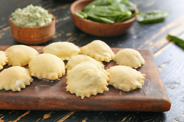 Raw ravioli on wooden board