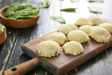Raw ravioli on wooden board